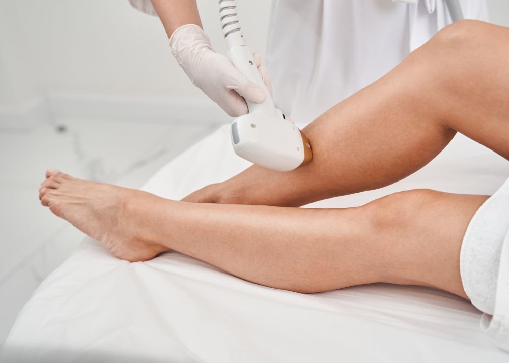 Profissional realizando depilação a laser nas pernas em ambiente clínico